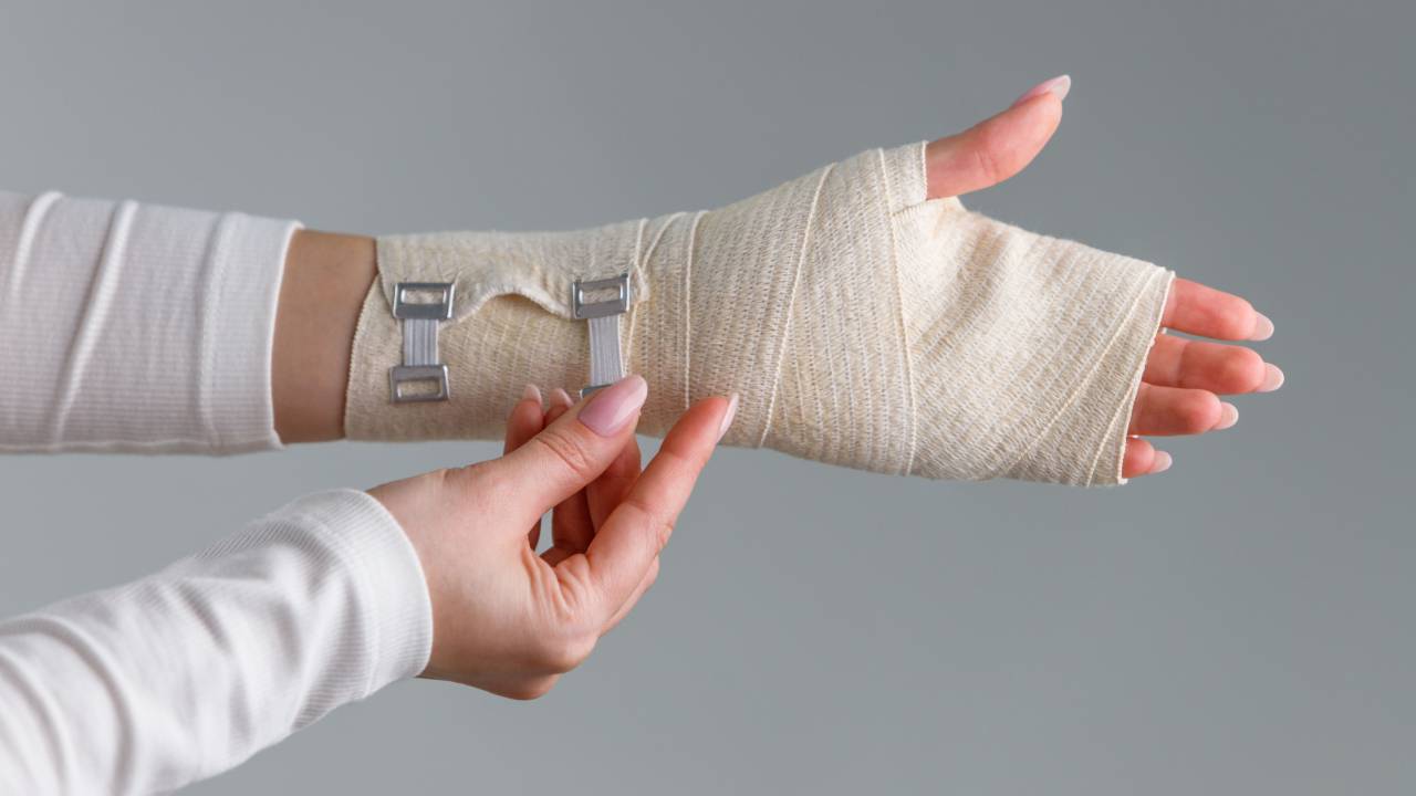 Λεπτομερής άποψη ενός νάρθηκα καρπού με μεταλλικά στηρίγματα, που προσαρμόζεται στο χέρι ενός ατόμου